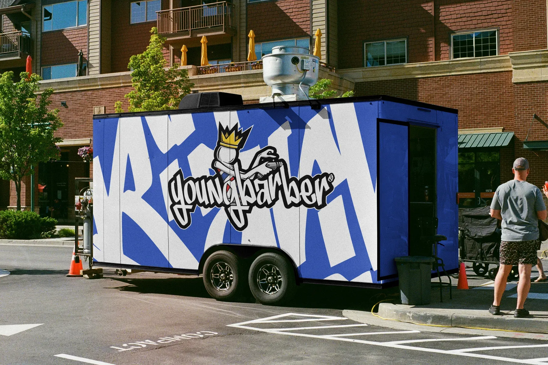 Mobile barbershop trailer in blue with white lettering