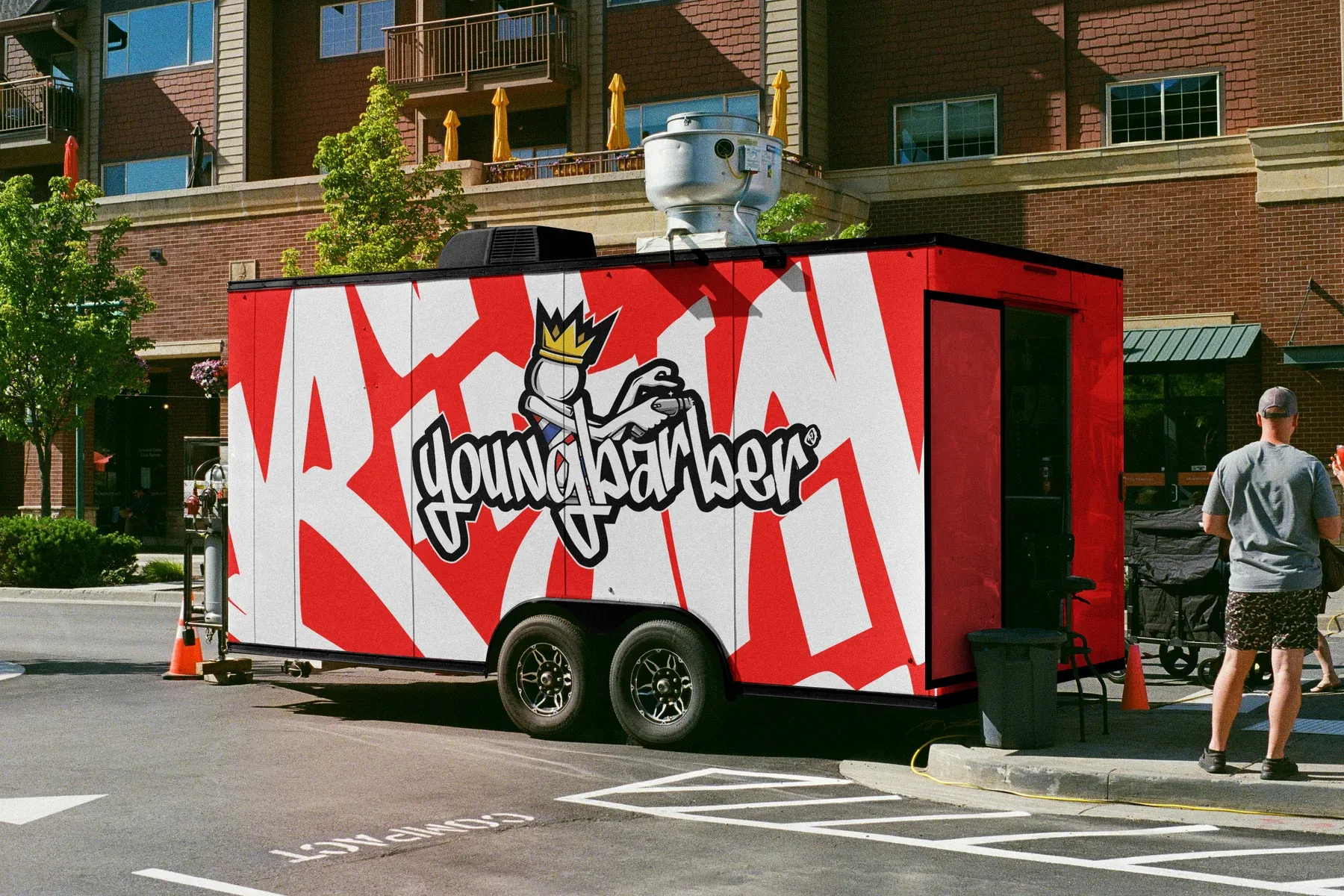 Mobile barbershop trailer in red with white lettering